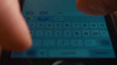 Genç adam mesajlaşmak için akıllı telefonun beyaz dokunmatik klavyesini kullanıyor. Makro yakın plan