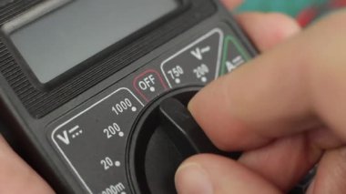 Elektronik çoklu metre alet gücü açık. Voltaj ölçümü için hazır. Kapat.