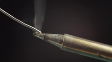 Eritilmiş lehim teli kızgın bir lehimleme demirinin ucunda. Çok yakın çekim..