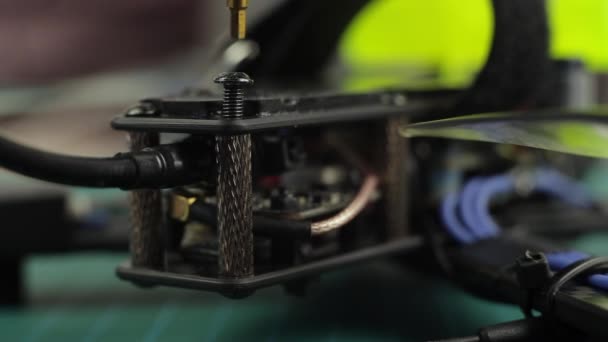 Extremo acercamiento de manos de hombres jóvenes ensamblando drones de carreras FPV usando destornillador . — Vídeos de Stock