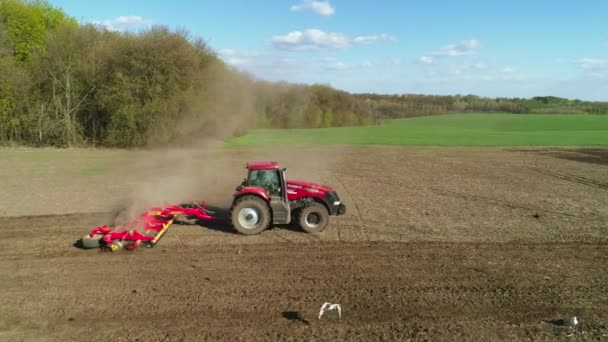 Vitachiv, Oekraïne - 23 april 2020: Luchtfoto van tractor aan het werk in het veld met een moderne zaaimachine in een nieuw geploegd veld. Mechanisatie van zaaizaad planten. — Stockvideo