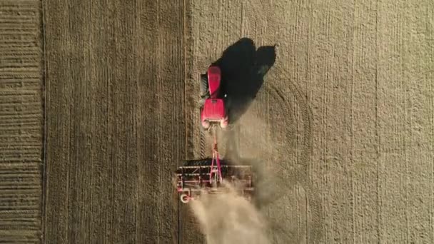 Flygfoto ovanifrån av traktor som arbetar i fält med en modern såfrömaskin i ett nyplöjt fält. Mekanisering av såddfrön. — Stockvideo