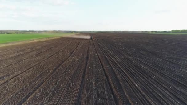 Вид с воздуха на работающий в поле трактор с современной сеялкой в недавно вспаханном поле. Механизация посевных семян. 27 апреля 2020 г. Витачев, Украина — стоковое видео