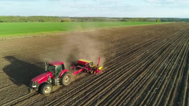 Vue aérienne du tracteur travaillant sur le terrain avec une machine moderne de semis dans un champ nouvellement labouré. La mécanisation des semences. 27 avril 2020 Vitachiv, Ukraine — Video