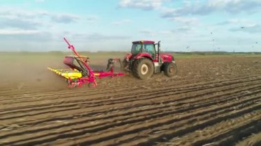 Tarlada çalışan traktörün hava görüntüsü yeni sürülmüş bir tarlada modern bir tohum ekme makinesiyle. Tohum ekme makineleşmesi. 27 Nisan 2020 Vitachiv, Ukrayna