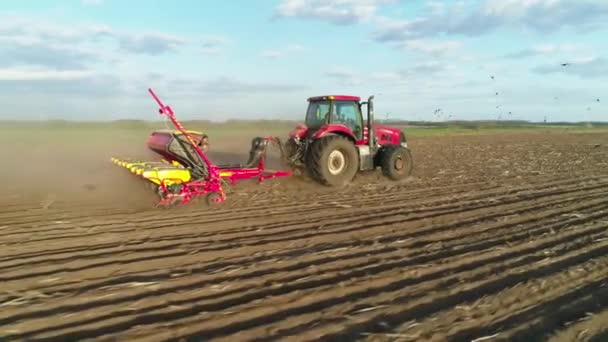 Tarlada çalışan traktörün hava görüntüsü yeni sürülmüş bir tarlada modern bir tohum ekme makinesiyle. Tohum ekme makineleşmesi. 27 Nisan 2020 Vitachiv, Ukrayna — Stok video