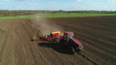 Vitachiv, Ukrayna - 23 Nisan 2020: Yeni sürülmüş bir tarlada modern bir tohum ekme makinesi ile tarlada çalışan traktörün havadan görünüşü. Tohum ekme mekanizasyonu.