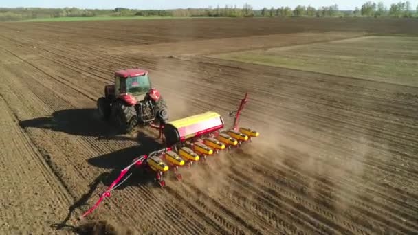 Vitachiv, Ukrajina - 23. dubna 2020: Letecký pohled na traktor pracující na poli s moderním secím strojem na nově oraném poli. Mechanizace výsadby semen. — Stock video