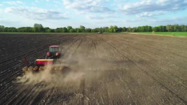 Tarlada çalışan traktörün hava görüntüsü yeni sürülmüş bir tarlada modern bir tohum ekme makinesiyle. Tohum ekme makineleşmesi. 27 Nisan 2020 Vitachiv, Ukrayna