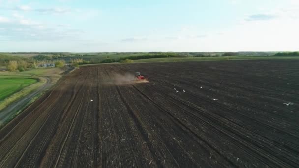 Flygfoto av traktor som arbetar i fält med en modern sådd frömaskin i ett nyplöjt fält. Plantering av frömekanisering. 27 april 2020 Vitachiv, Ukraina — Stockvideo