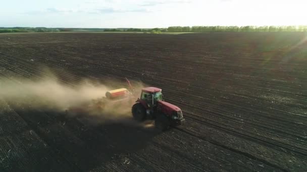 在一个新耕作的田里，用现代播种机在田里干活的拖拉机的空中景象。播种种子机械化。2020年4月27日 — 图库视频影像