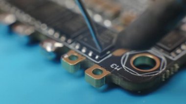 ESC bağlantıları lehimleniyor. FPV yarış uçağı monte eden genç adamların elleri aşırı yakın çekim.