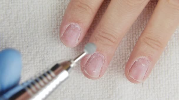 Jonge vrouw verwijdert gel schellak van nagels met behulp van manicure machine — Stockvideo