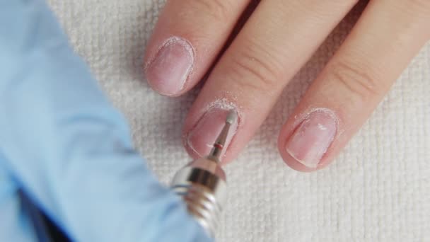 Mujer joven elimina gel goma laca esmalte de las uñas utilizando la máquina de manicura — Vídeo de stock