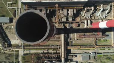 Güneşli bir günde dumansız büyük, kırmızı ve beyaz bacaların yukarıdan aşağıya insansız hava aracı görüntüsü