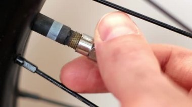 Bisiklet tekerleğinin kapağını kapatıyorlar. Makro çekim