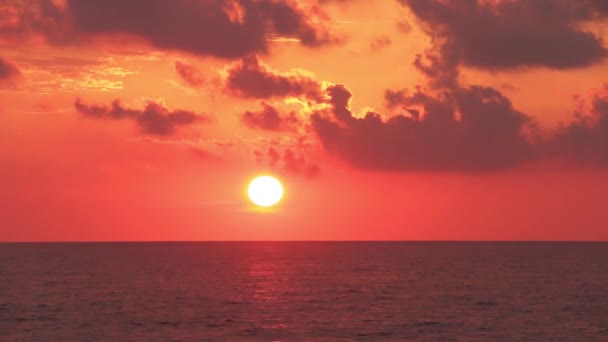 A lenyugvó nap mögött a felhők; óceán a láthatáron — Stock videók