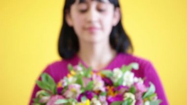 Hoş Latin bir bayan sunar. Muhteşem bir buket, sarı parlak bir arka plan.