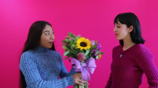 Dos Niñas Oliendo Inspeccionando Bonito Ramo Flores Fondo Rosa — Vídeo de stock