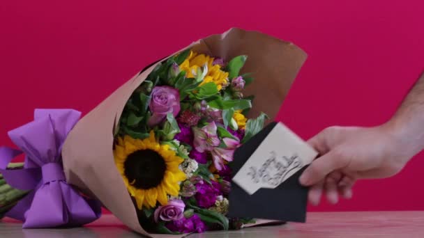 Man Hand Placing Birthday Note Next Bouquet — Stock Video