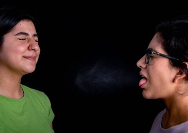 Hasta kadın öksürüyor, başka bir kadının yüzüne hapşırıyor. 