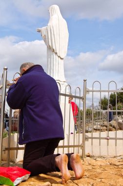 Bir adam medjogorje Madonna'nın heykeli önünde dua