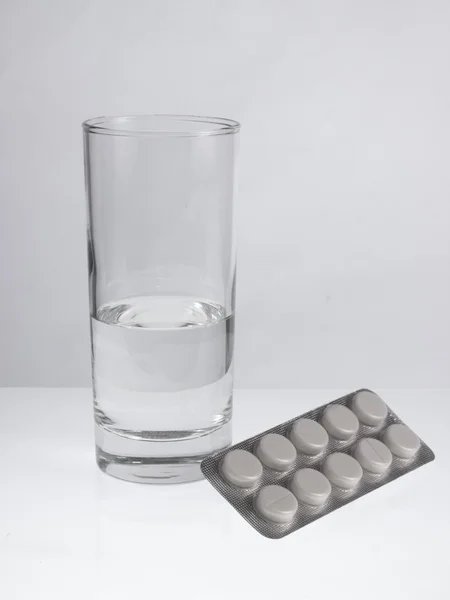 Glass of water and pills — Stock Photo, Image