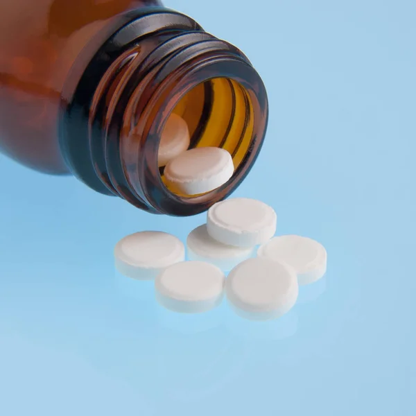 White pills poured out of bottle — Stock Photo, Image