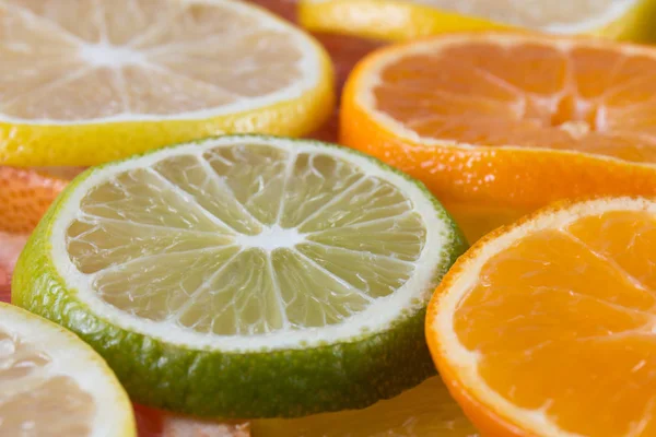 Orange, Zitrone, Limette, Mandarine in Scheiben geschnittene Zitrusfrüchte Hintergrund — Stockfoto