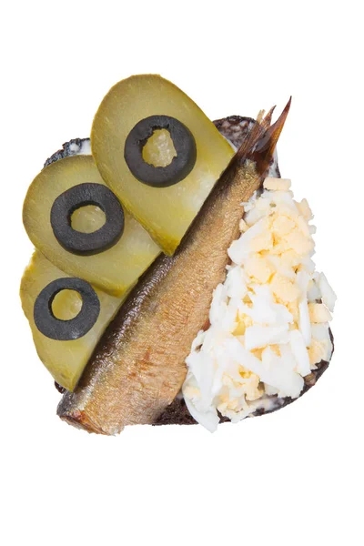 Спраты, яйца и огурцы на ржаном хлебе на белом — стоковое фото
