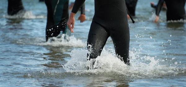 Triatletas correndo no mar — Fotografia de Stock