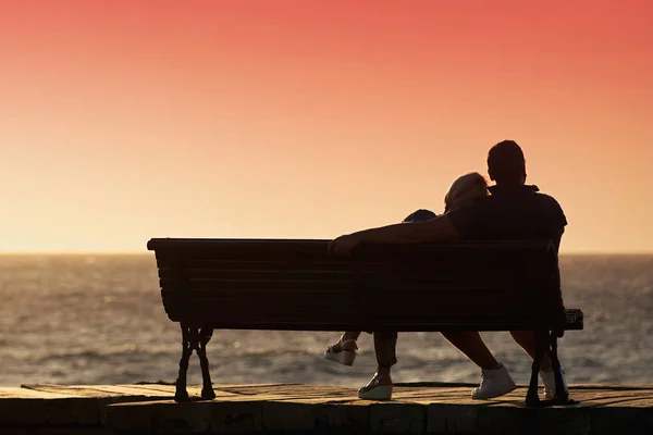 Silhouette couple romantique sur un banc — Photo