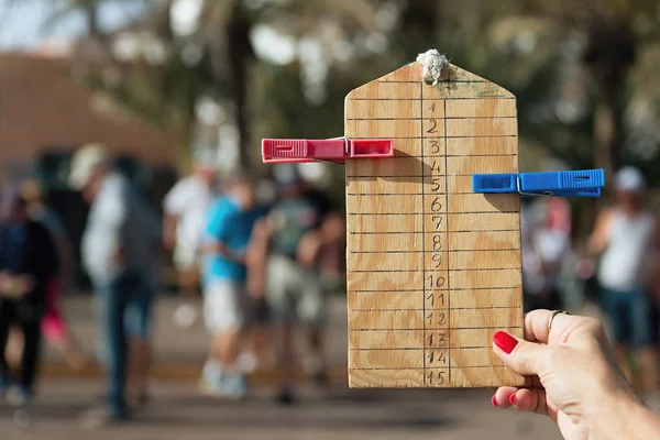 Frau hält die Partiturtafel des Petanque in der Hand — Stockfoto