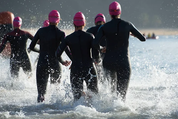 Triathlonteilnehmer laufen zum Schwimmen ins Wasser — Stockfoto