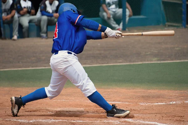 Jugador de liga masculina en camisa azul balanceándose en una pelota lanzada —  Fotos de Stock