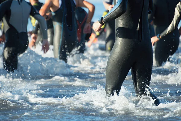 Triathletes τρέχει έξω από το νερό — Φωτογραφία Αρχείου