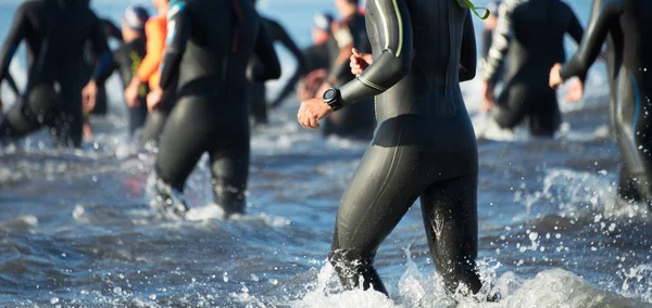 Triathletes τρέχει έξω από το νερό — Φωτογραφία Αρχείου