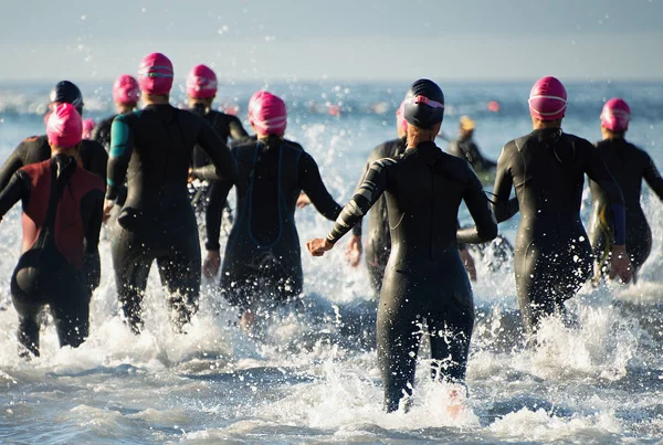 Triathlonteilnehmer laufen ins Wasser — Stockfoto