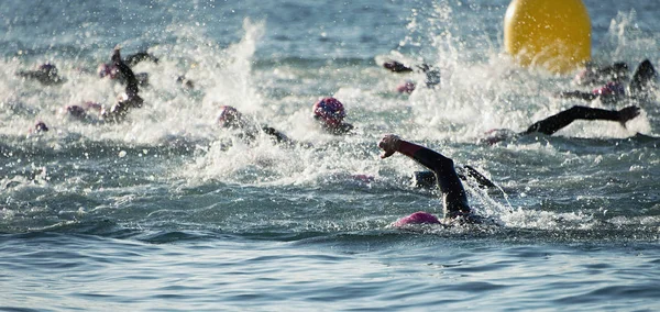 Group people in wetsuit swimming at triathlon