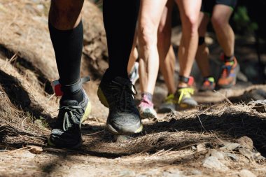 Dağ yolu egzersiz üzerinde çalışan grup iz, eylem closeup eylem koşu ayakkabıları dondur