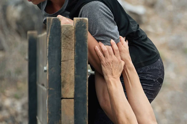 Teilnehmer Hilft Beim Hindernislauf Über Ein Hindernis Klettern — Stockfoto