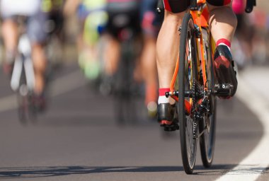 Bisiklet yarışında yarışan sporcular, yüksek hızda yarışan sporcular, vites tekerlekleri ve ayakları üzerinde detay.