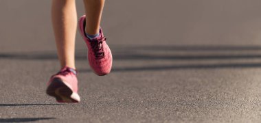 Koşucu ayakları yolda koşuyor. Ayakkabıya yakın, maraton koşusu.