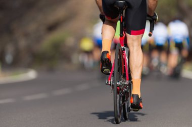 Bisiklet yarışında yarışan sporcular, yüksek hızda yarışan sporcular, vites tekerlekleri ve ayakları üzerinde detay.