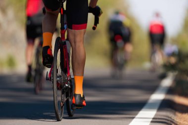 Bisiklet yarışında yarışan sporcular, yüksek hızda yarışan sporcular, vites tekerlekleri ve ayakları üzerinde detay.