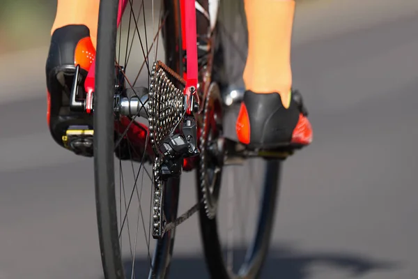 Racing bike detail on gear wheels and feet