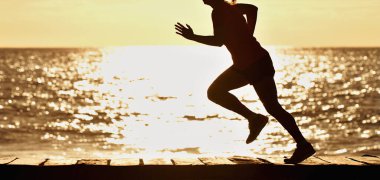 Gün doğumunda sahilde koşan bir kadın, spor salonu.