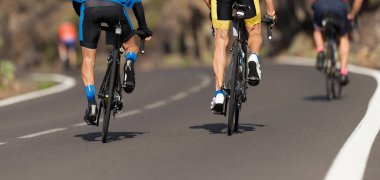 Bisiklet yarışında yarışan sporcular, yüksek hızda yarışan sporcular, vites tekerlekleri ve ayakları üzerinde detay.