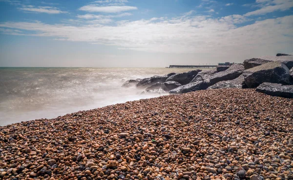 Steiniger Strand in aller Eile und ein neuer Steg in der Ferne — Stockfoto