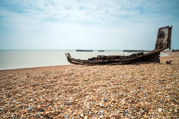 Bleibt ein altes hölzernes Fischerboot am steinigen Strand in aller Eile — Stockfoto